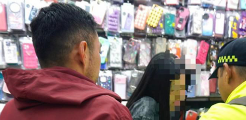 Policía hablando con una mujer en un almacén en compañía de un gestor del orden