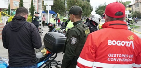 Policía hablando con un hombre en la calle en compañía de un gestor del orden