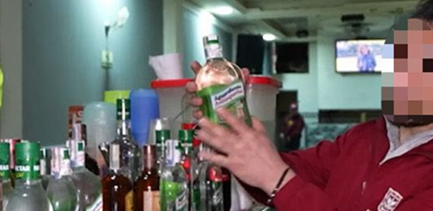 Hombre con botellas de licor incautadas