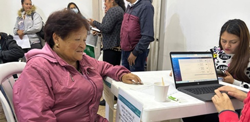 Una mujer sentada con otra en una mesa