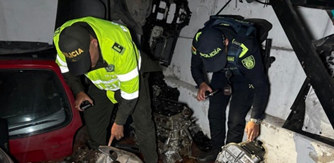 Dos policías revisando piezas de automóviles