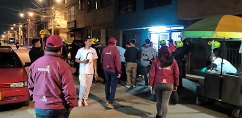 Hombres y mujeres a las afueras de un bar en Suba