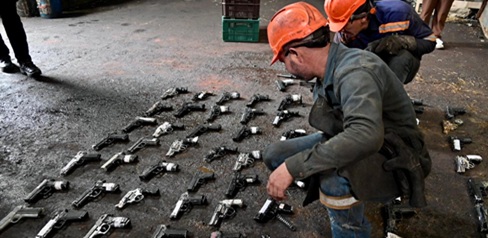 Hombre con varias armas en el piso