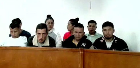 Varias personas sentadas en una banca 