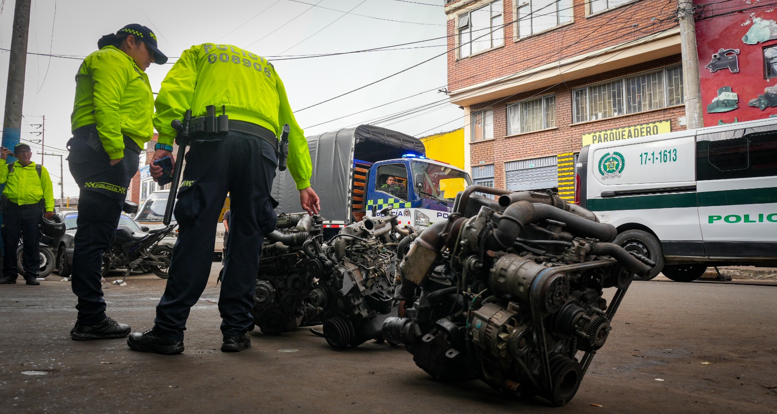 Capturados, motores incautados y establecimientos sellados: así fue el megaoperativo en zona de autopartes en Los Mártires Un hombre y una mujer policía revisando autopartes