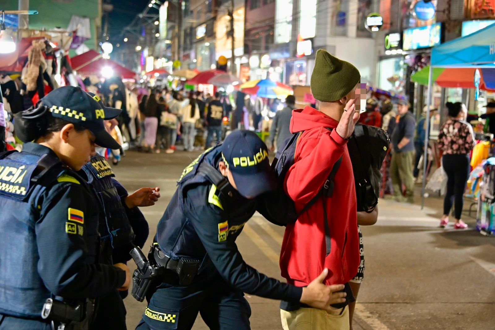 ¿Cuál es la diferencia entre hurto y estafa?: aprenda a identificar estos delitos y por qué es clave saberlo para denunciar a tiempo en Bogotá Hombre siendo requisado por varios miembros de la policía