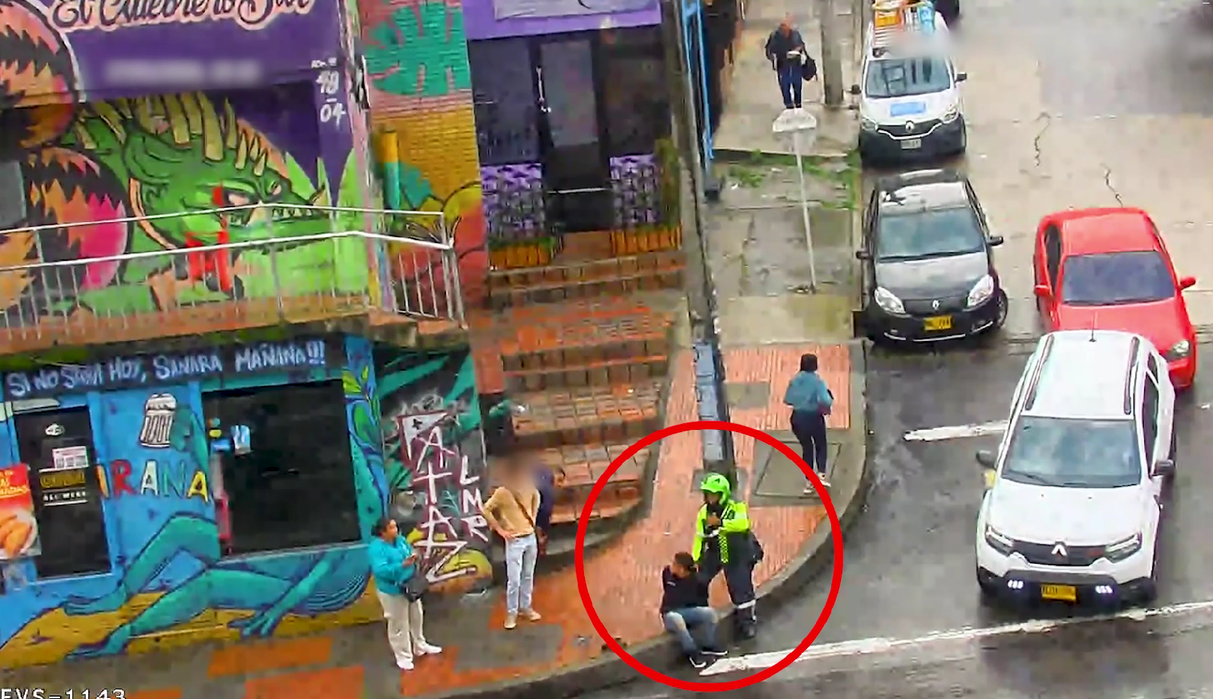Carros y personas transitando por la calle y policía deteniendo a un hombre
