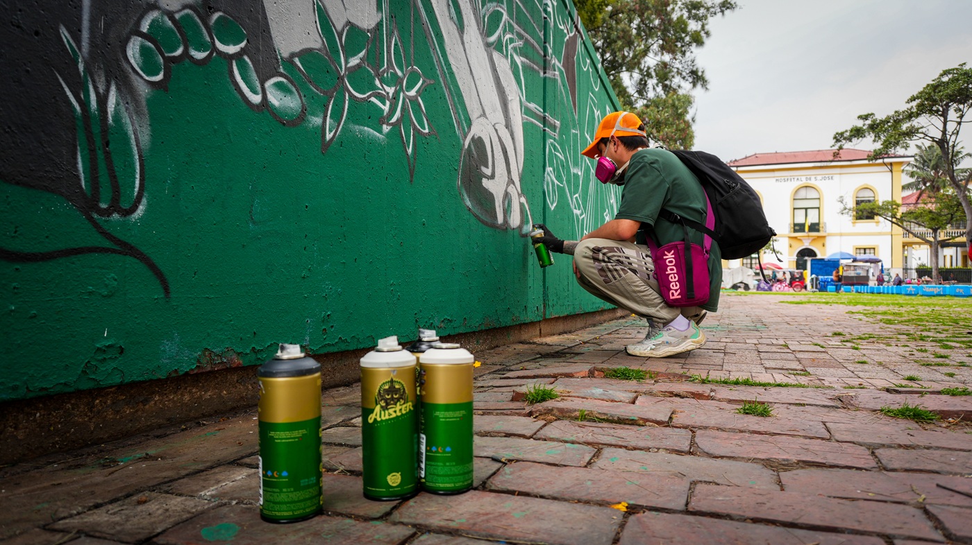 De cambuches, basura y foco de inseguridad a espacio recuperado: la nueva cara de Plaza España Hombre pintando un grafitti