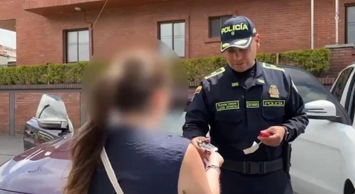 Fueron recuperados 4 vehículos de alta gama que habían sido hurtados de un taller en Barrios Unidos. Policía entregando las llaves de un carro a una mujer