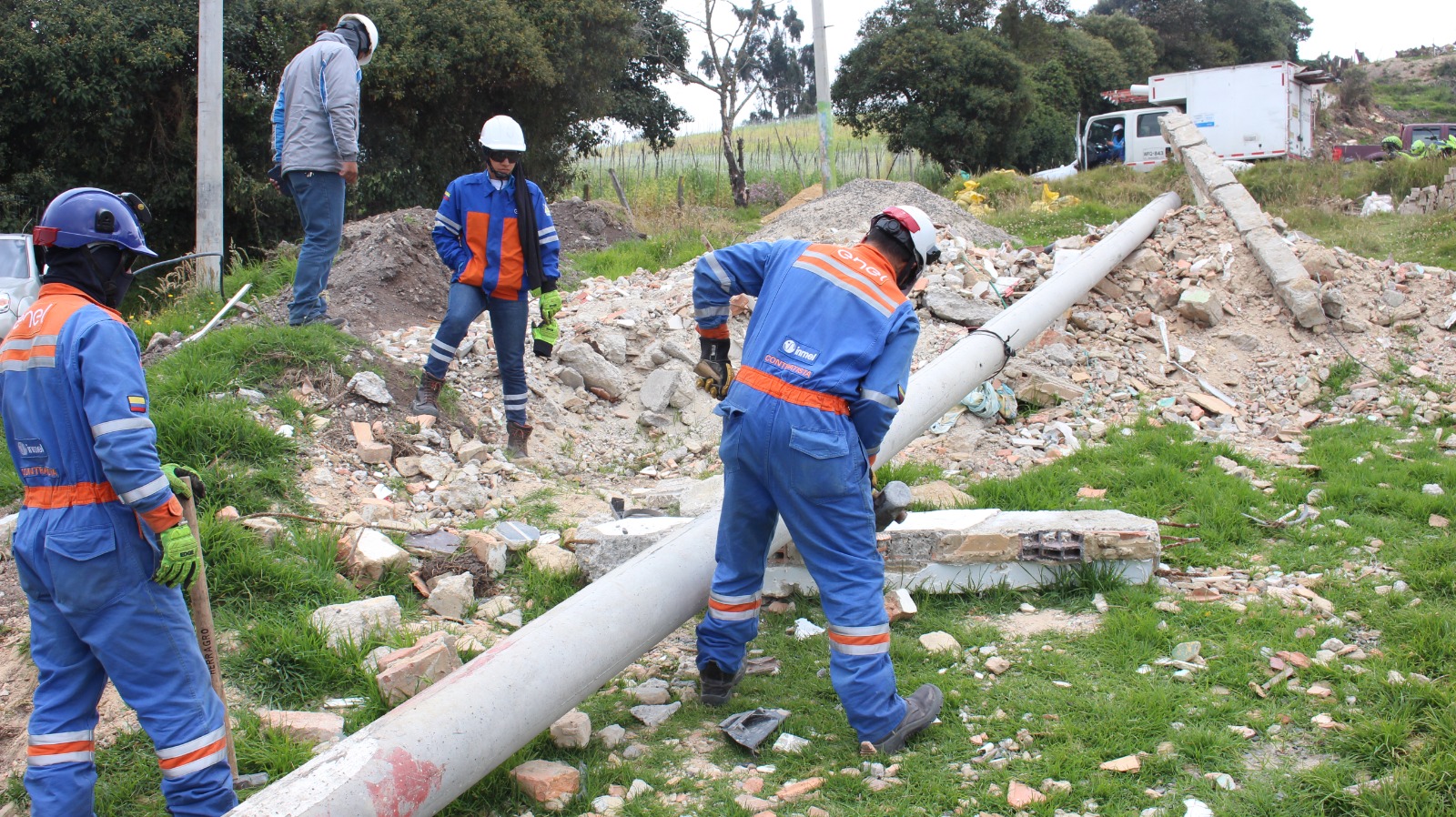 Golpe a tierreros en Usme: desmontan red de postes usada para vender lotes en zona protegida Cuatro hombres quitando un poste de la luz