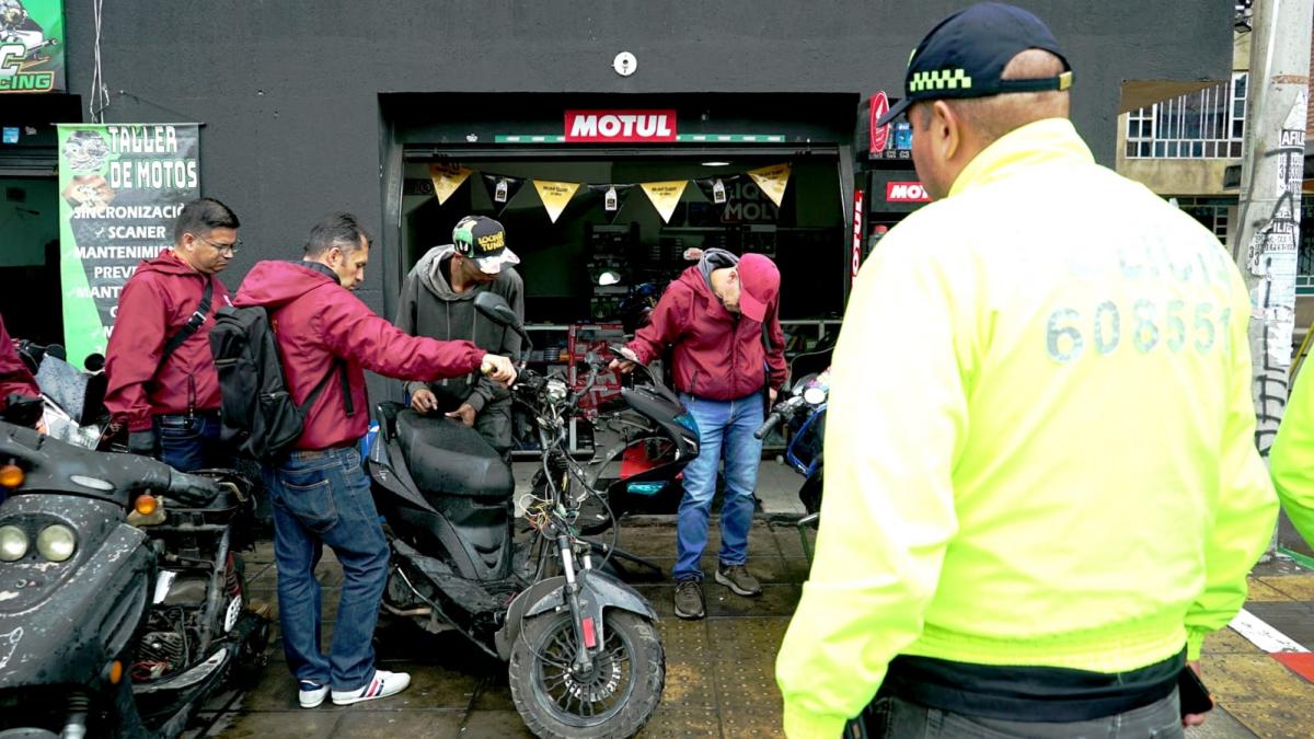 Funcionarios y Policía inspeccionando motocicletas Funcionarios y Policía inspeccionando motocicletas