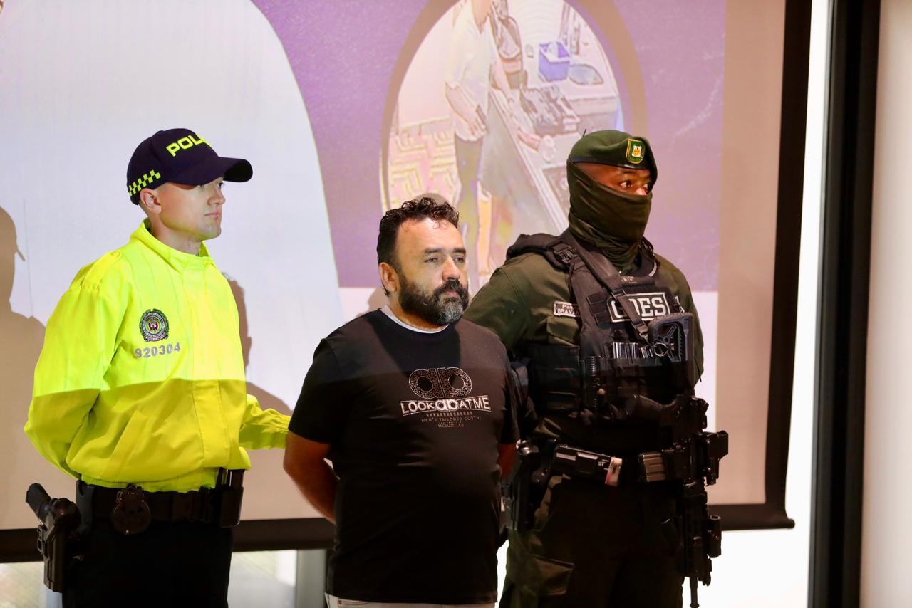 Un hombre capturado junto a un policía y hombre del Goes