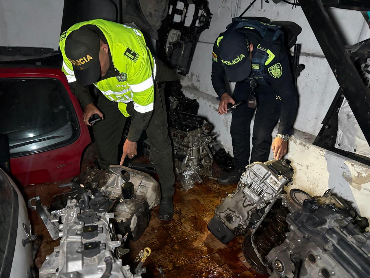 Dos policías revisando piezas de automóviles