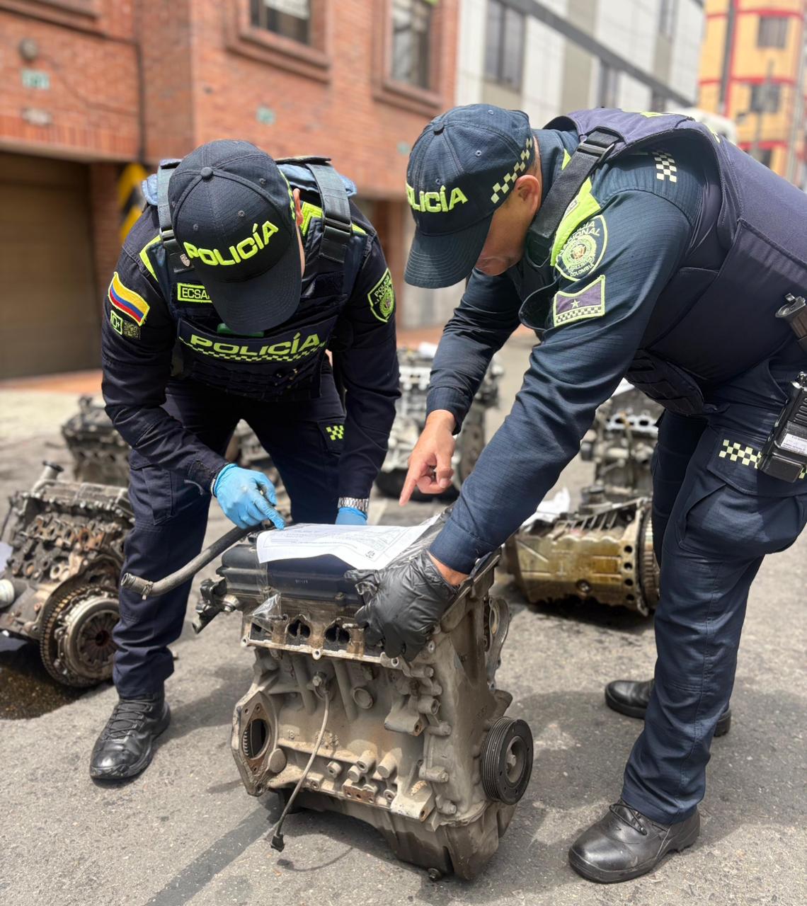 Dos policías revisando piezas de automóviles