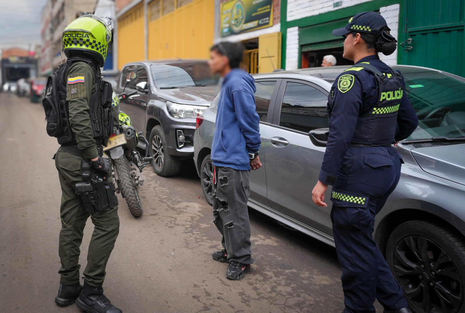 Un hombre esposado junto a dos policías