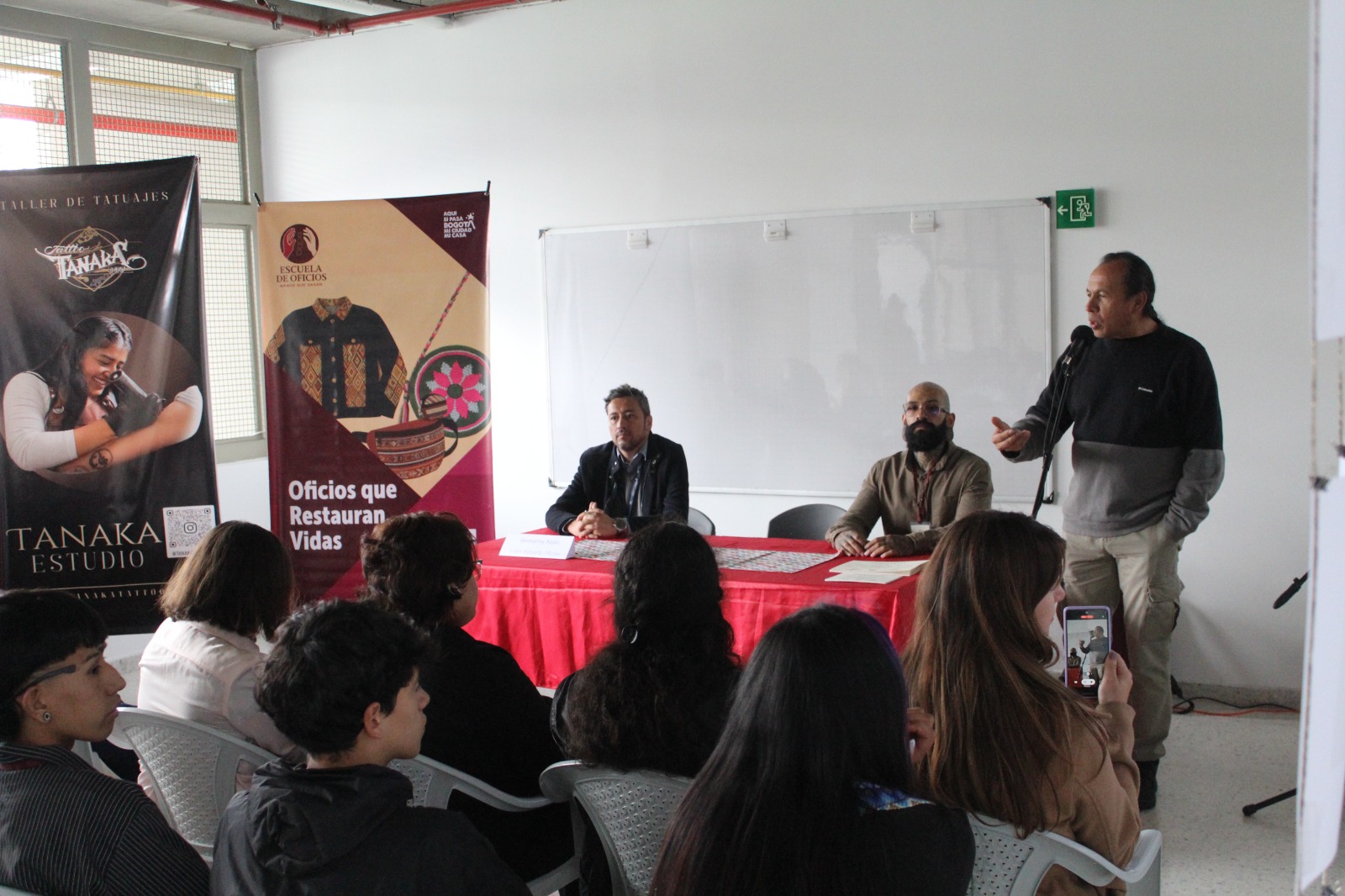 20 jóvenes se graduaron del curso de tatuaje de la Escuela de Oficios Varias personas recibiendo una charla