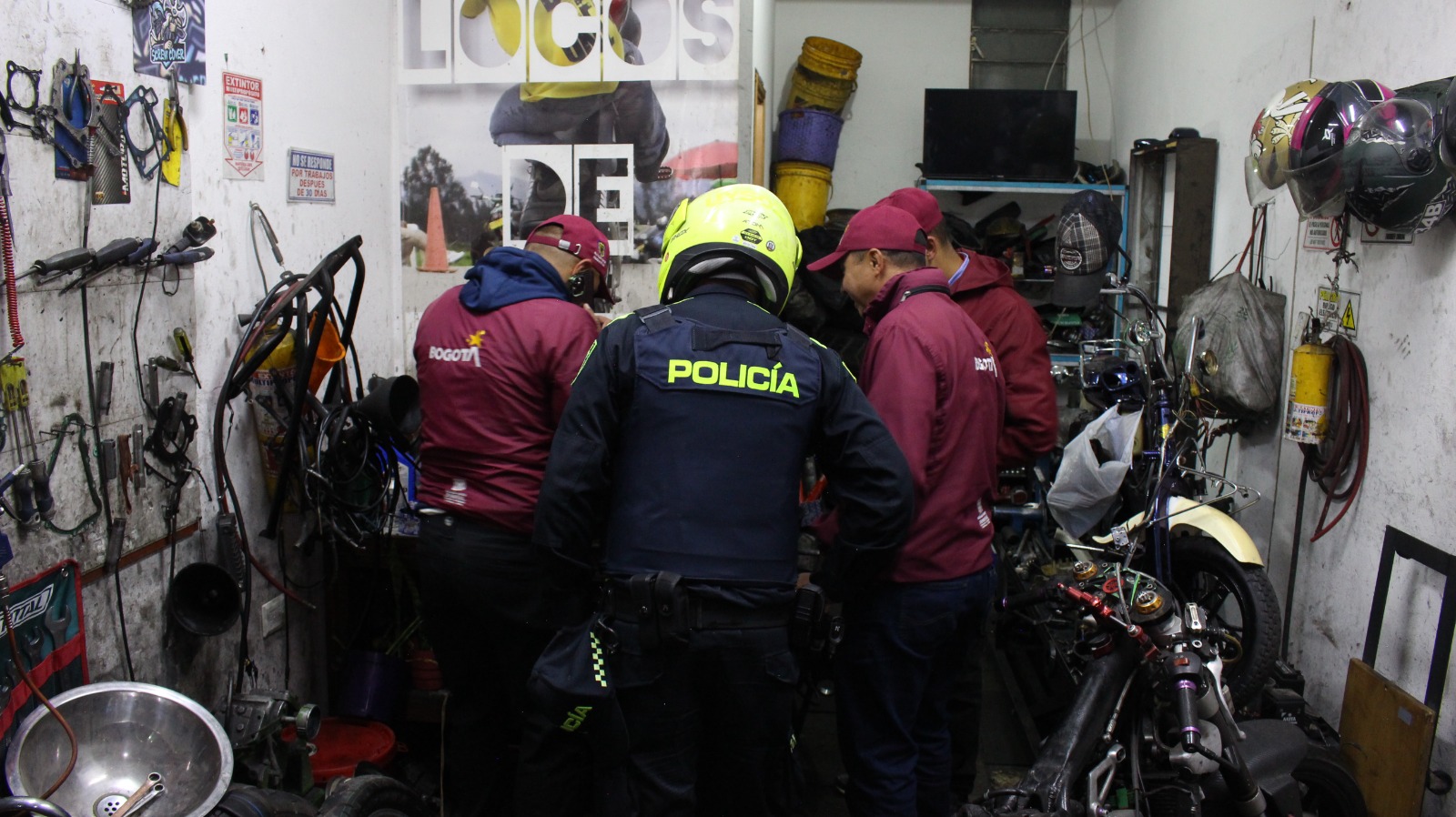 Varios hombres revisando un taller de motos