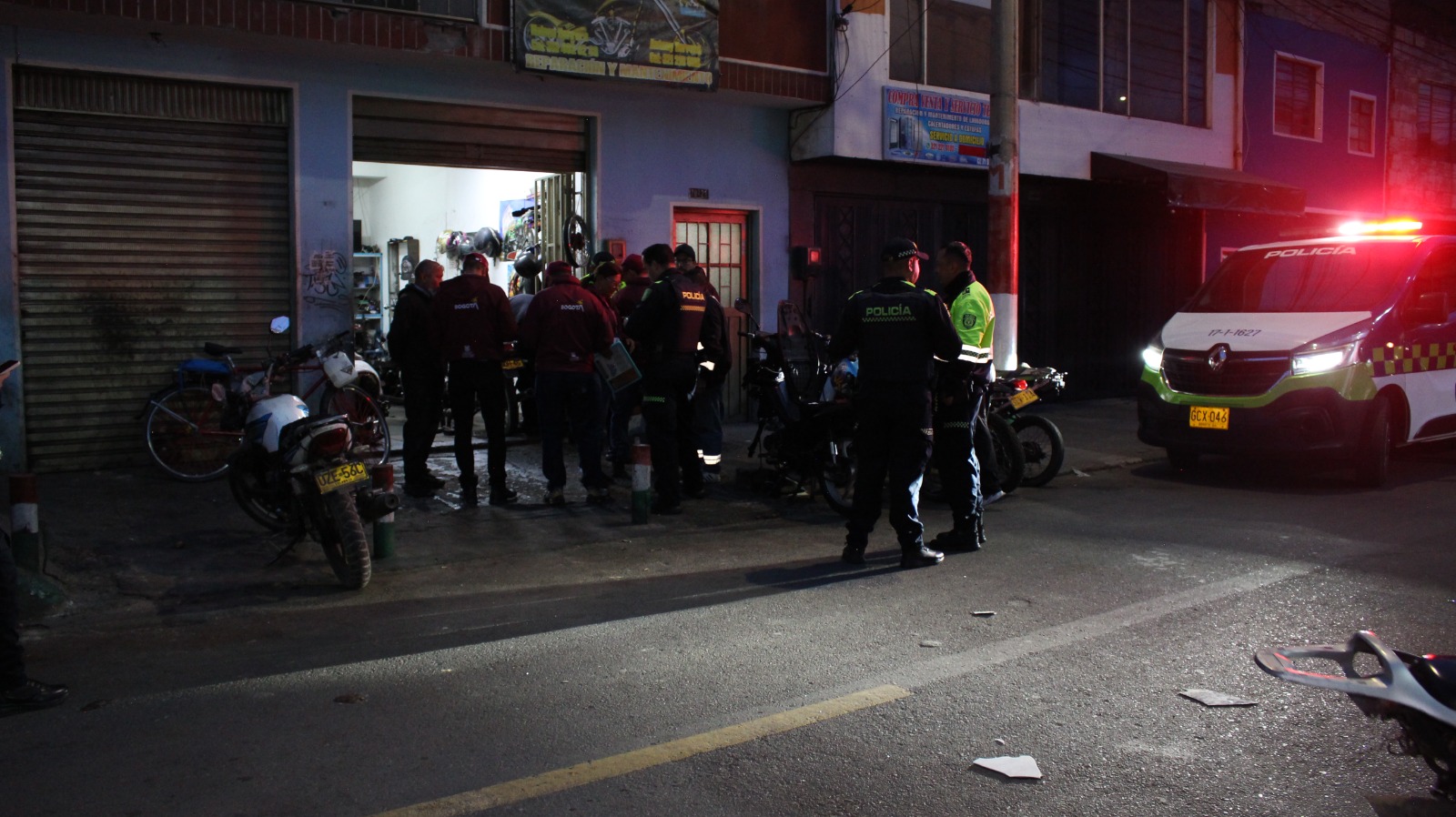 Varios hombres revisando un taller de motos