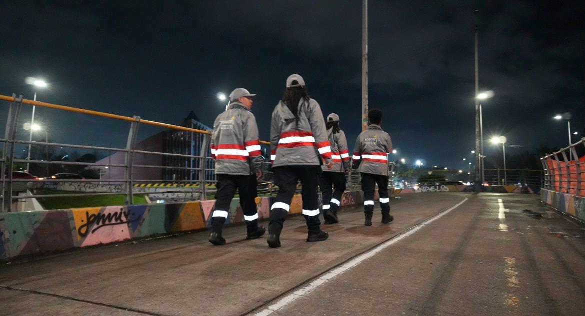 Cuatro gestores del orden caminando de noche
