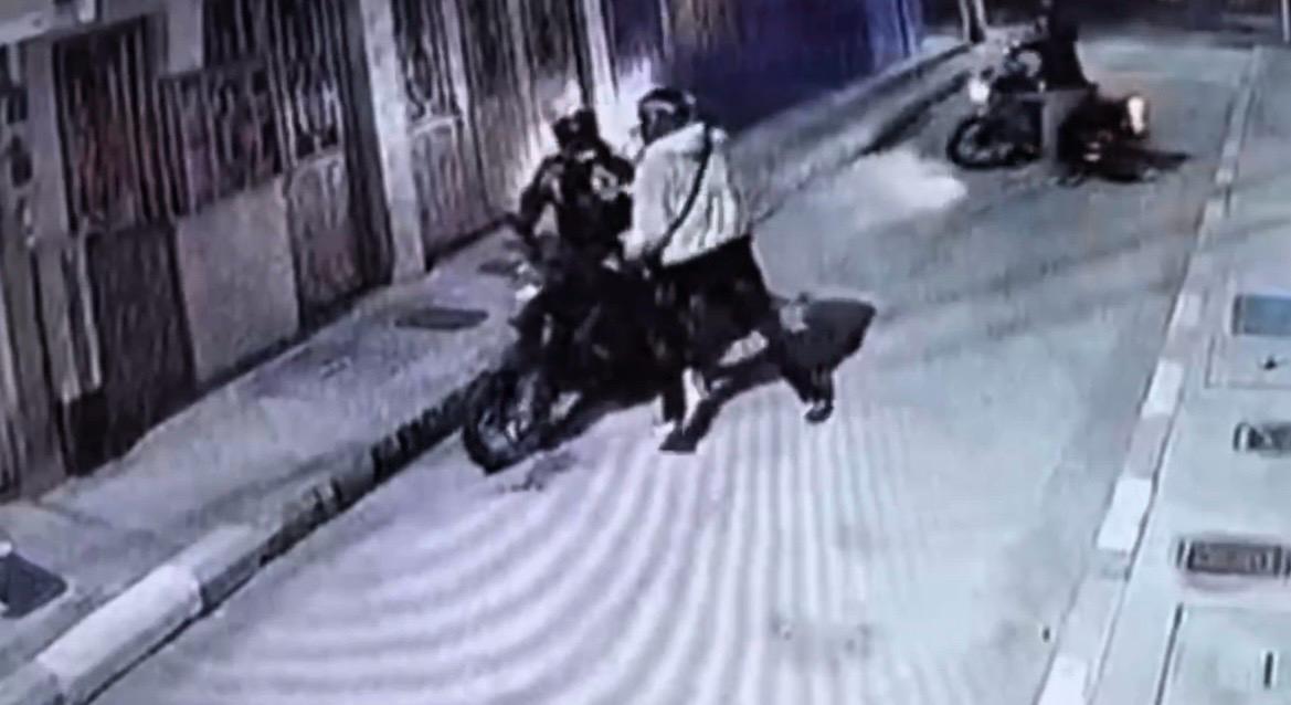 Dos hombres es motos y un hombre de pie