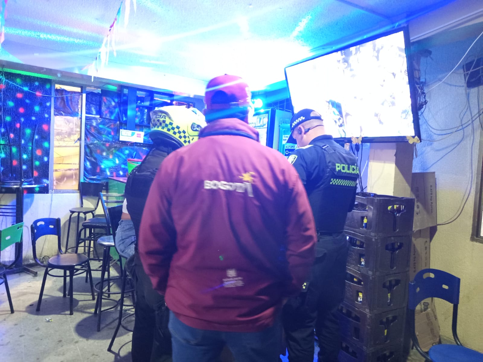 Hombres y mujeres a las afueras de un bar en Suba