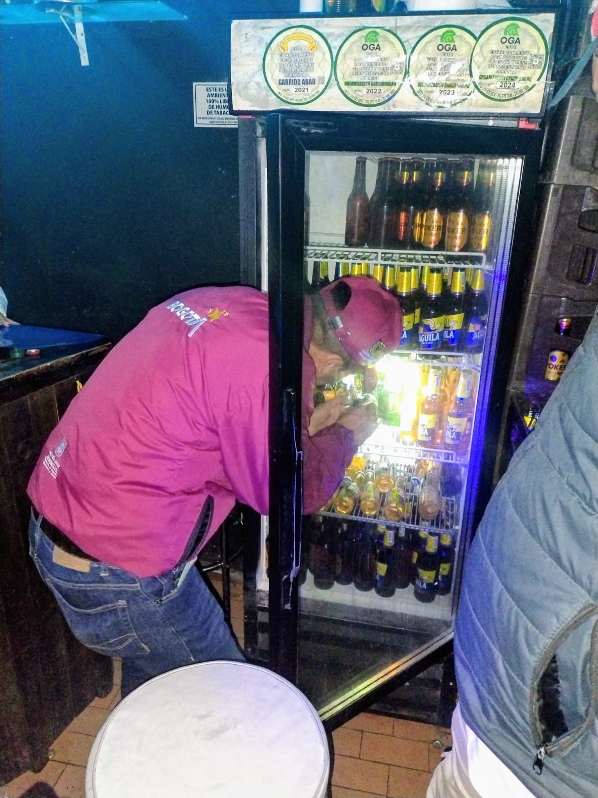 Hombre abriendo un refrigerador donde hay cervezas