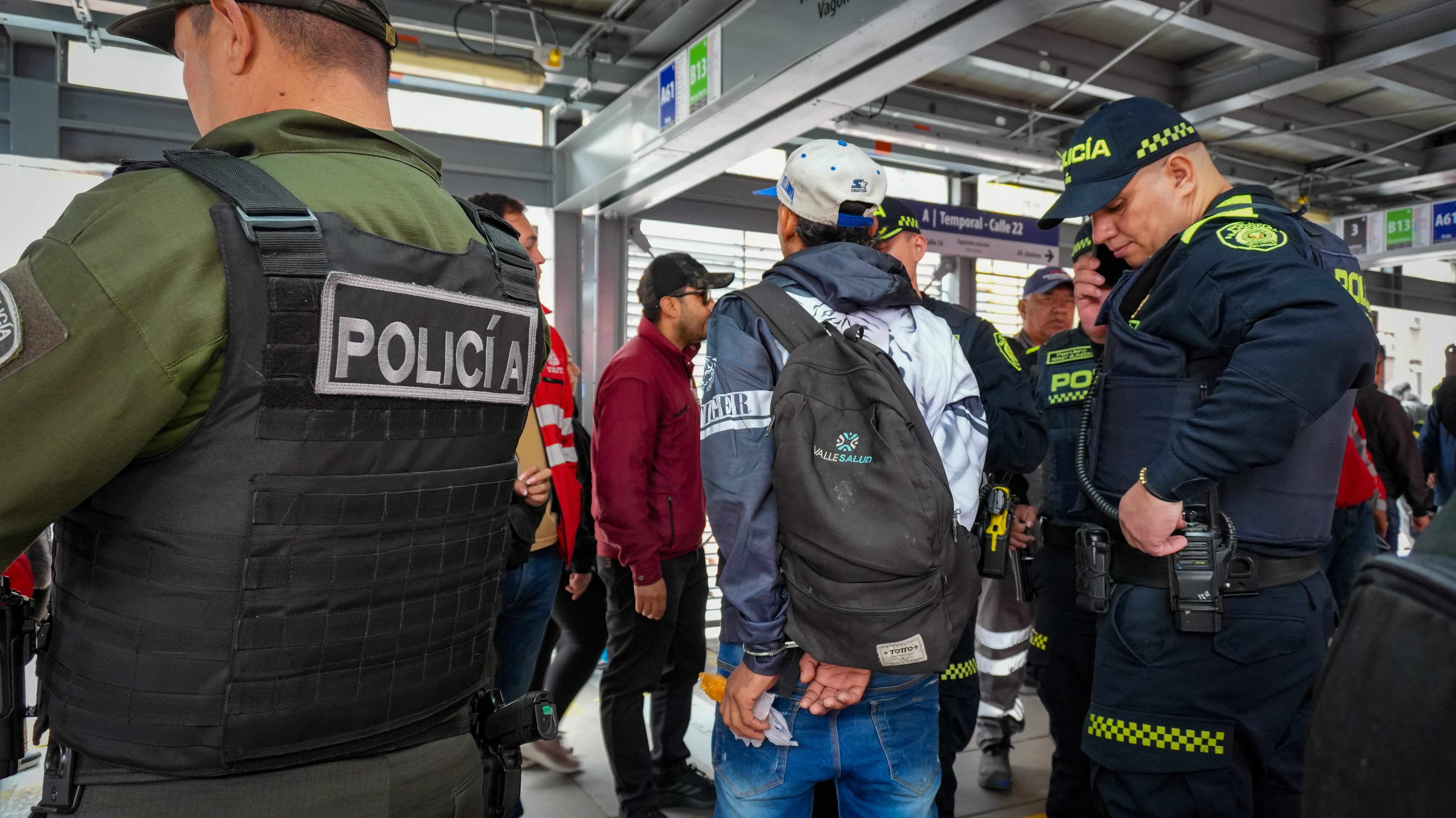 Varias personas y policías dentro de un vagón de transmilenio