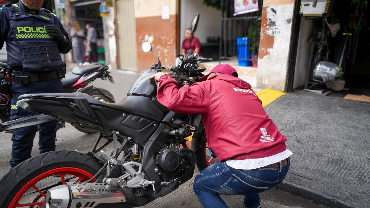 Un hombre junto a una motocicleta