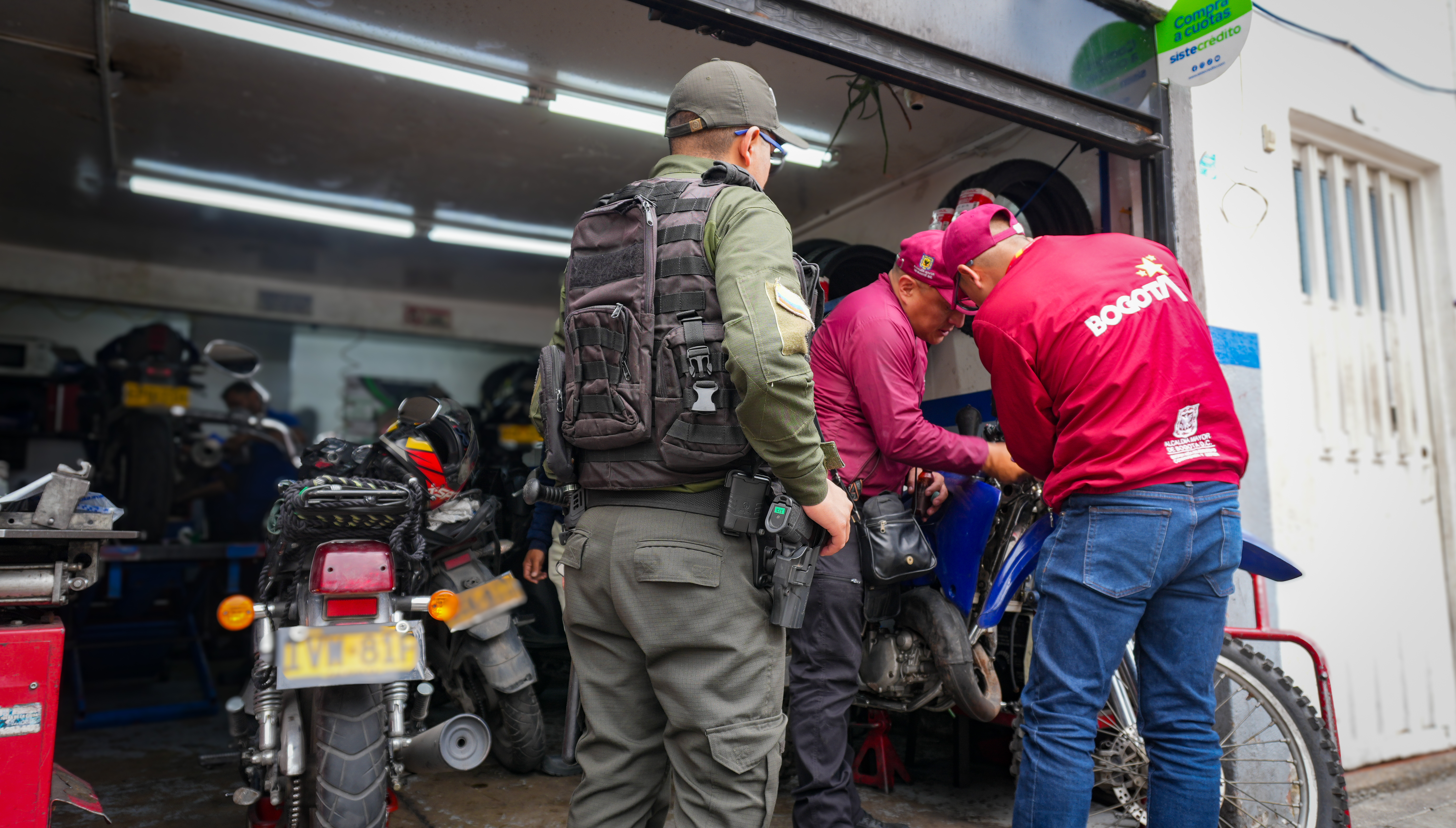 Funcionarios de la alcaldía y policía revisando una motocicleta