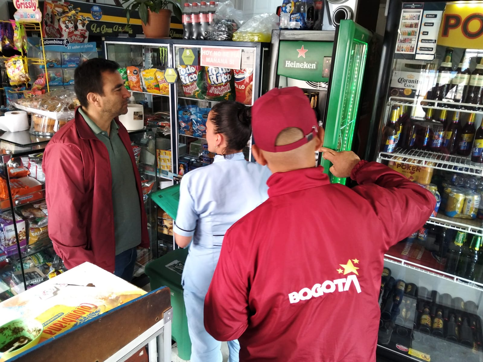 Hallan niño de 4 años en estado de abandono y capturan a tres personas por hurto durante operativo en pagadiarios de Santa Fe Dos hombres y una mujer hablando en una tienda