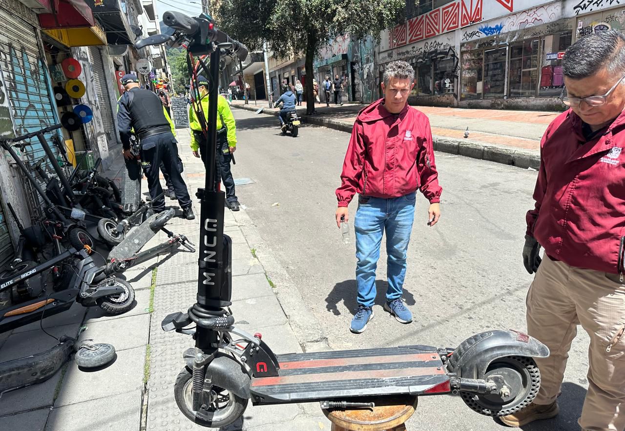 Varios hombres y policía con patinetas eléctricas