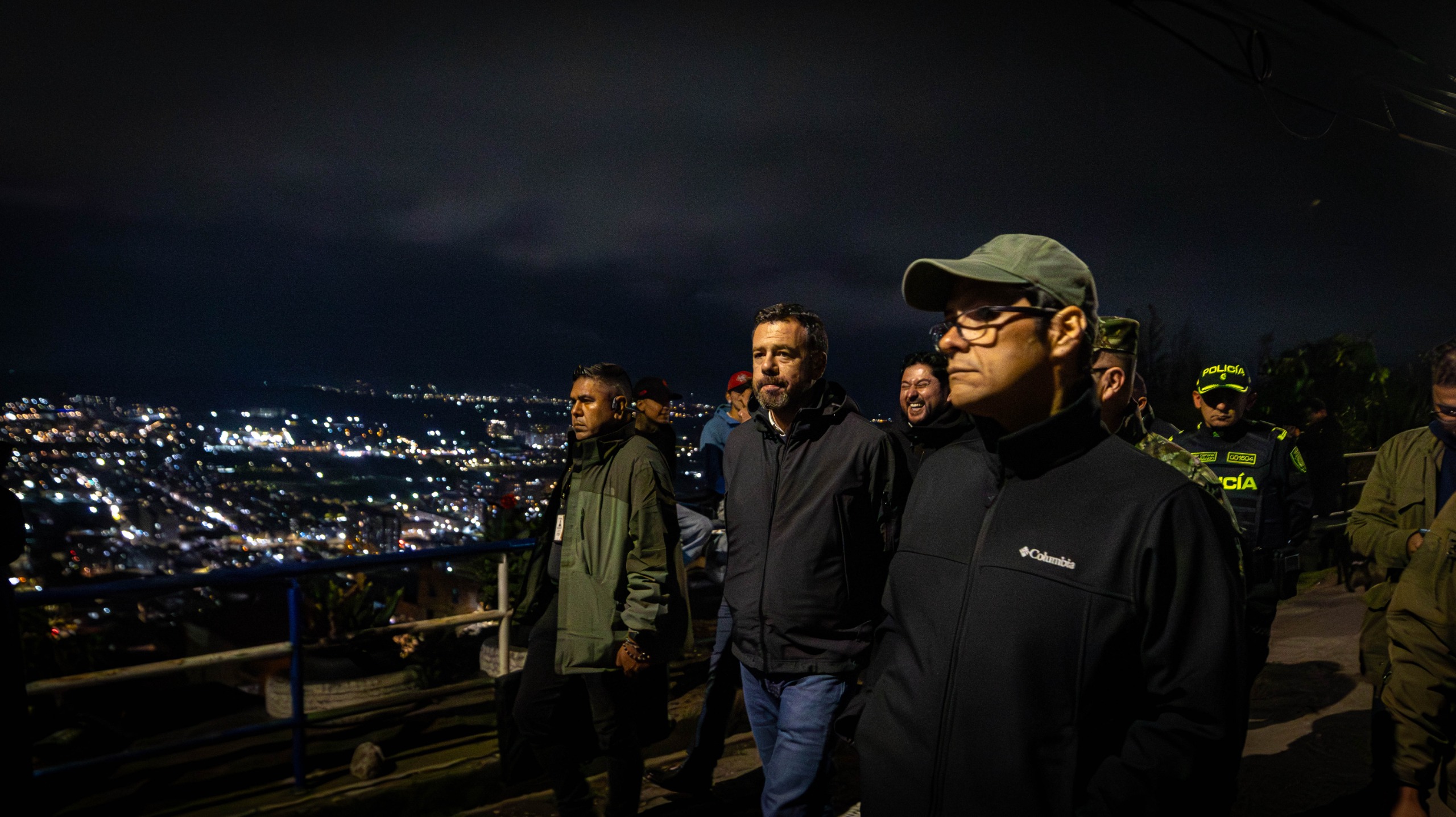 Varios hombres caminando de noche por una calle