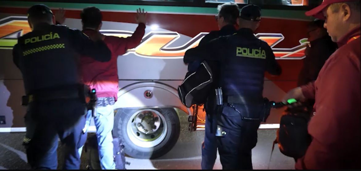 Autoridades intensifican operativos en las entradas y salidas de Bogotá para prevenir delitos Dos policías requisando a dos hombres