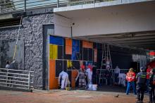 Varias personas embelleciendo fachada de un puente