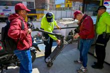 Cuatro hombres revisando patinetas eléctricas