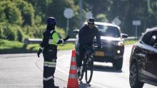 Hombre montado bicicleta y policía cuidando la ruta