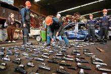 Hombres con armas próximas a destruir en el piso