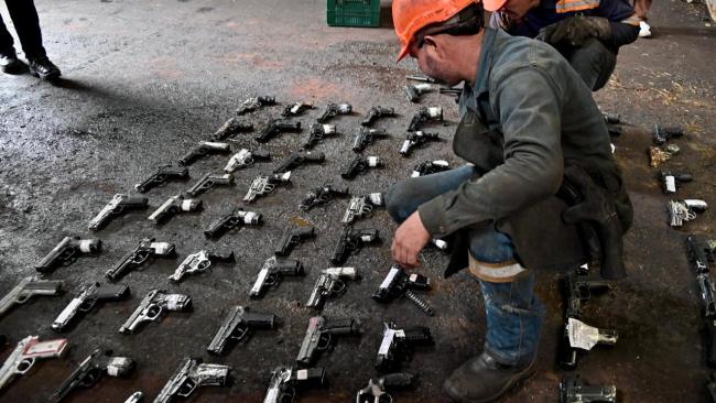 Hombre con armas próximas a destruir en el piso